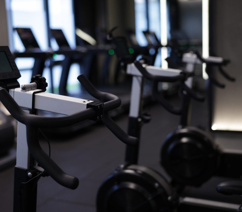 Many modern professional bicycle machines in gym, closeup